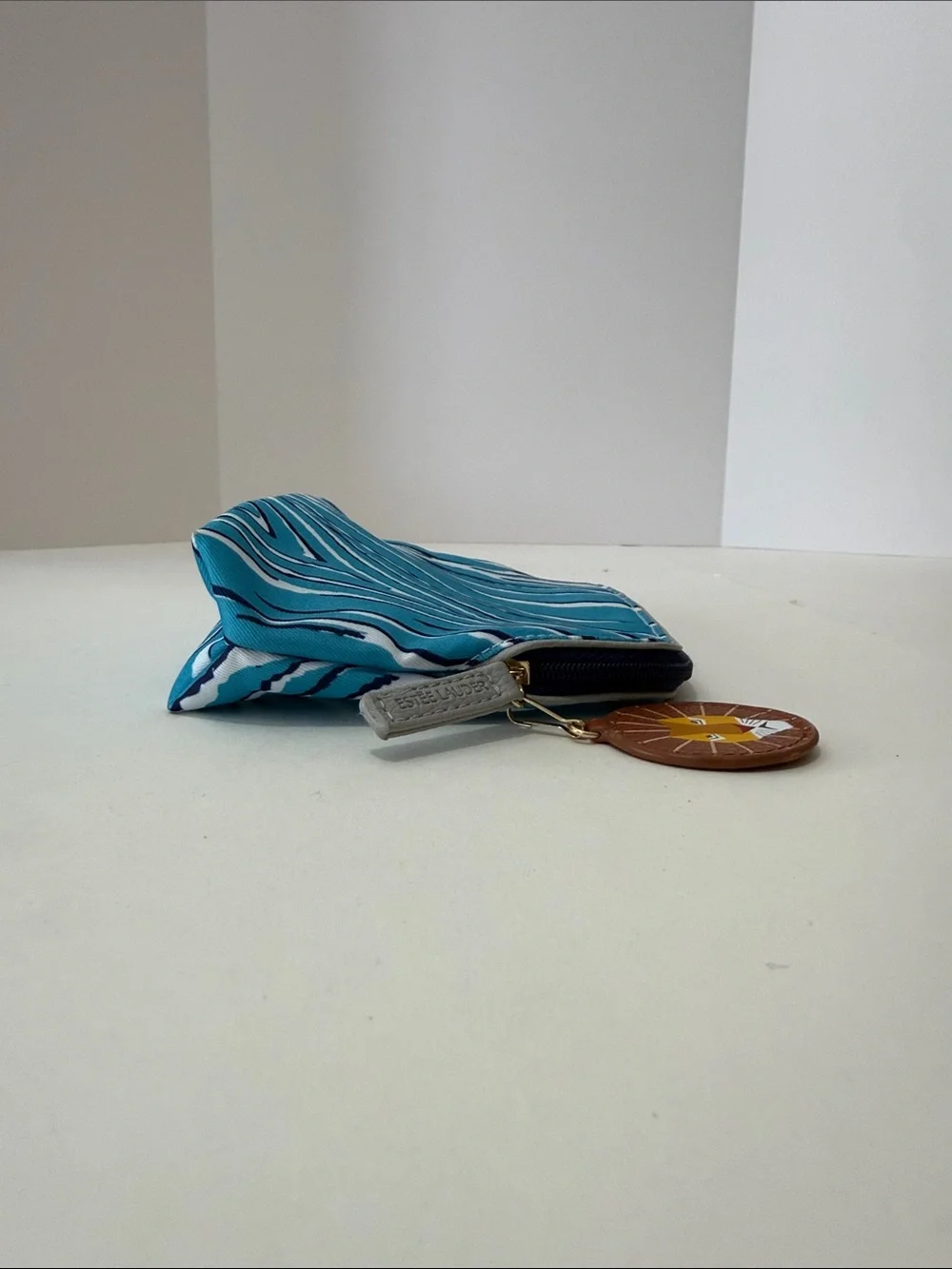 Estee Lauder Turquoise and White Zebra-Print Cosmetic Pouch with Lion Charm